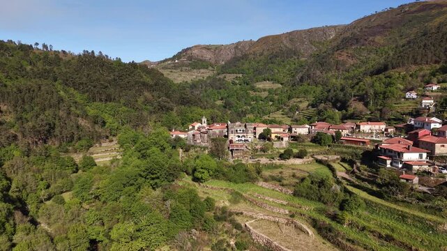 Sistelo village nestled in mountains with traditional stone houses and green terraced fields