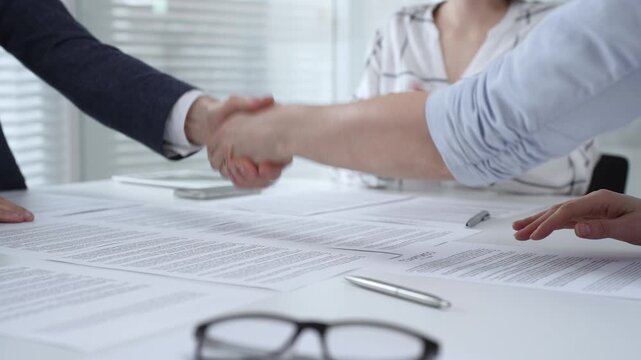 Business executives shaking hands, sealing an agreement after successful negotiations in a bright office, symbolizing partnership, collaboration, and a mutually beneficial deal signing