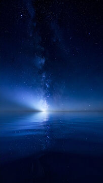 星空と天の川が映り込む鏡のような水面の夜景　静寂で幻想的な雰囲気を持つコピースペース付きの縦型背景素材　Webサイトやポスターデザインに活用できる宇宙と自然の風景写真