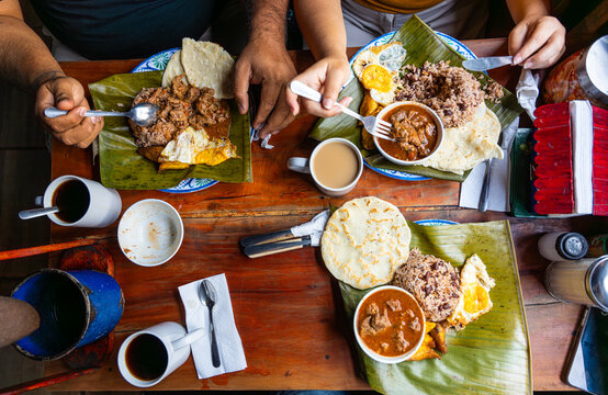 Family enjoying traditional central american breakfast on wooden table  in Costa Rica