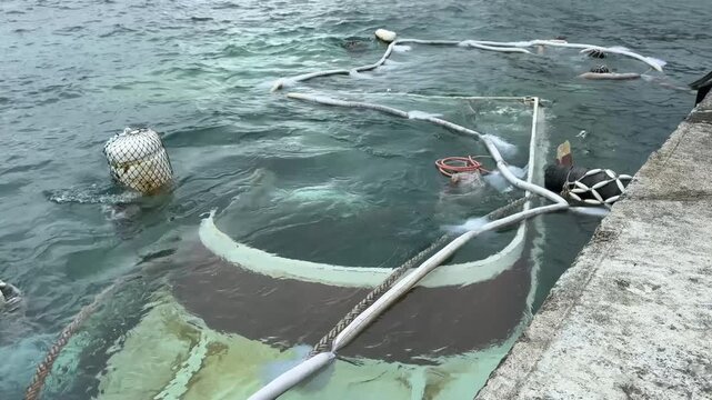 Oil spill response in Gongguan Fishing Port, Green Island, featuring oil absorbent booms on water surface.