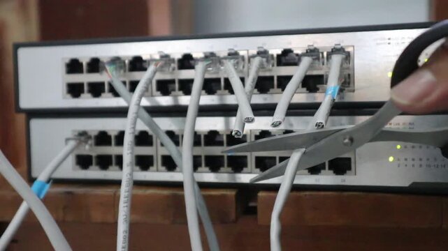 Disconnecting a internet network cable with scissors. 