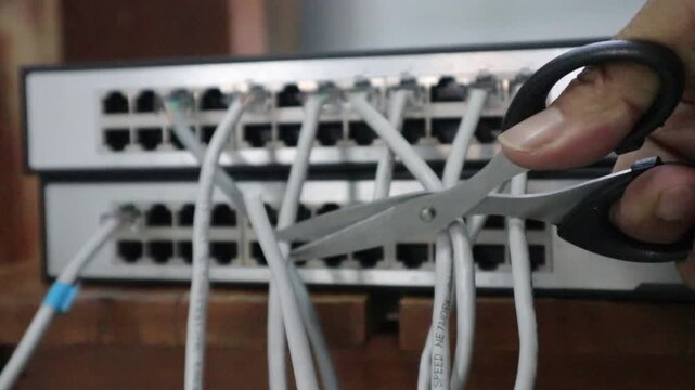 Disconnecting a internet network cable with scissors. 