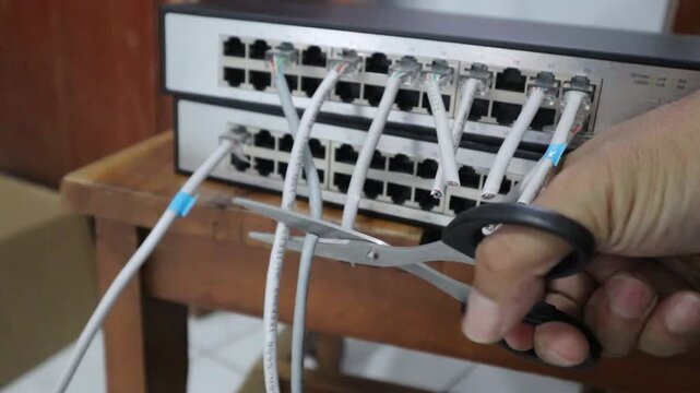 Disconnecting a internet network cable with scissors. 