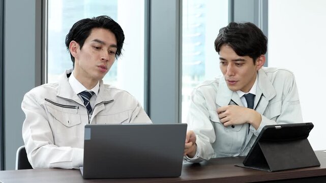 タブレットを使って打ち合わせを行う男性技術者のビジネス風景
