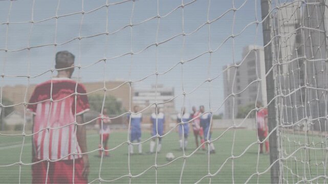 Soccer player in red kit stepping and kicking on ball placement, scoring into net