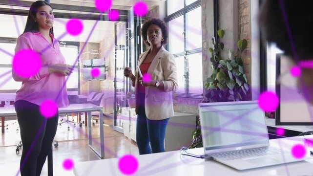 Woman in blazer gesturing with marker, initiating magenta nodes overlaying glass for tech demo