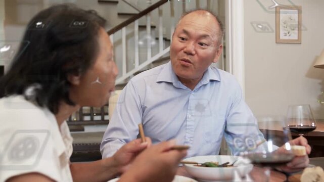Woman lifting noodles starting chat, man responding while tech UI icons overlaying dining table