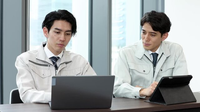 タブレットを使って打ち合わせを行う男性技術者のビジネス風景
