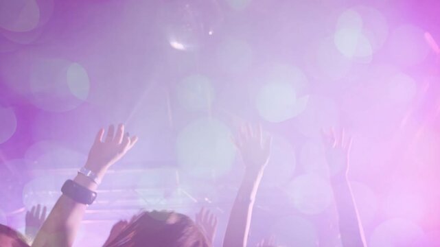 Beat cueing crowd hands rising and swaying, purple-pink haze bathing silhouettes, smiles appearing