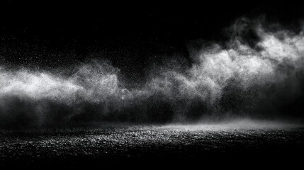 Naklejka premium This abstract image features a white dust cloud or smoke effect against a dark, black background. The particles are in motion, creating a dynamic and atmospheric texture across the frame.