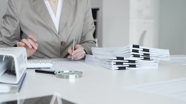 Businesswoman hands organizing stack of papers with binder clips, working on financial documents and official reports in office. Audit and taxes concept