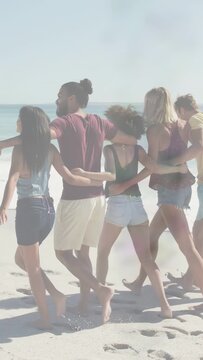 Vertical video: Group linking arms walking seashore glitch lines fading showing steps for travel ad