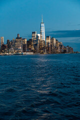 Fototapeta premium One World Trade Center and Lower Manhattan skyline night. Long shot of One World Trade Center and financial district skyline from Hudson River at twilight.