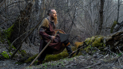 Viking warrior stands confidently amidst a misty forest, axe in hand and gaze fixed forward. © horimono