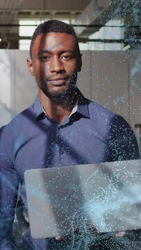 Vertical video: Man closing or opening eyes raising laptop prepping IT demo as blue dots sweeping fa