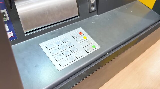 Close-up of hand entering pin code on ATM keypad, financial transaction motion footage.