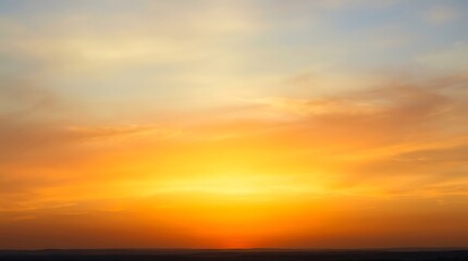 Obraz premium Vibrant sunset sky with layered orange, yellow, and blue clouds