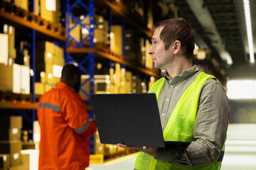 Fototapeta premium Male worker organizing packages in fulfillment center storage room. Inventory management system ensures accurate order fulfillment and workflow across large business operations.