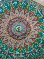 Fototapeta premium Intricate Islamic Calligraphy and Geometric Patterns Adorning a Mosque Dome Interior.