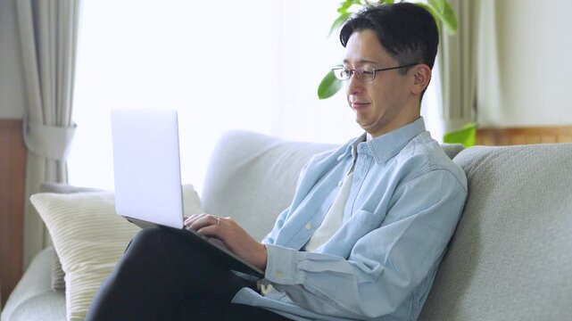 パソコンを使う男性のライフスタイルイメージ, Man Using Laptop at Home Lifestyle Concept
