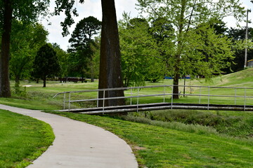 Fototapeta premium Sidewalk and Footbridge in a Park