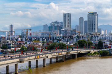 Fototapeta premium A wide shot of the Vinh Phuoc, Nha Trang, Khánh Hòa, Vietnam, with traffic crossing the bridge and the city skyline in the background.