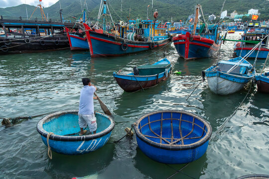 A fisherman prepares his coracle boat for fishing in the waters of Nha Trang, Vietnam.. These unique round boats are essential for coastal fishing.