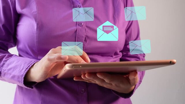 Close-up of a businesswoman interacting with her tablet, an animation of several closed and one open envelope icons.