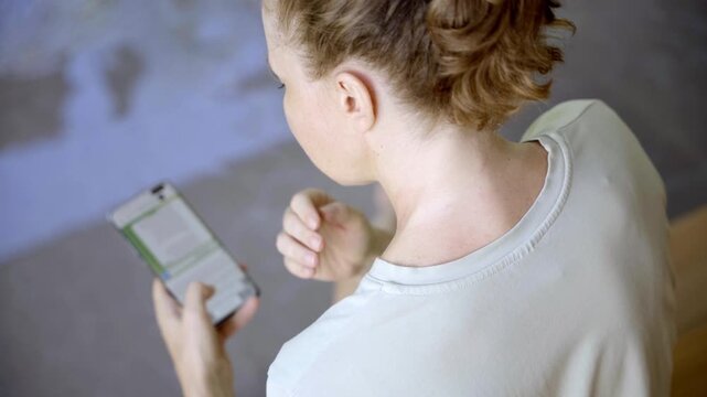 Woman feeling neck discomfort while using mobile phone