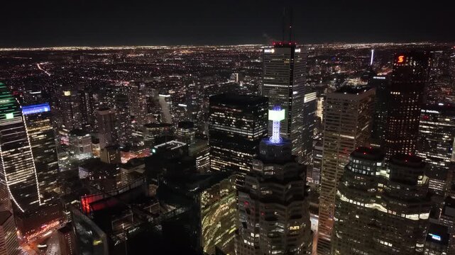 A cinematic 360-degree aerial orbit over Toronto&rsquo;s Financial District at night, featuring the illuminated BMO Field tower, Scotiabank Plaza, and the dense urban lights of the downtown core