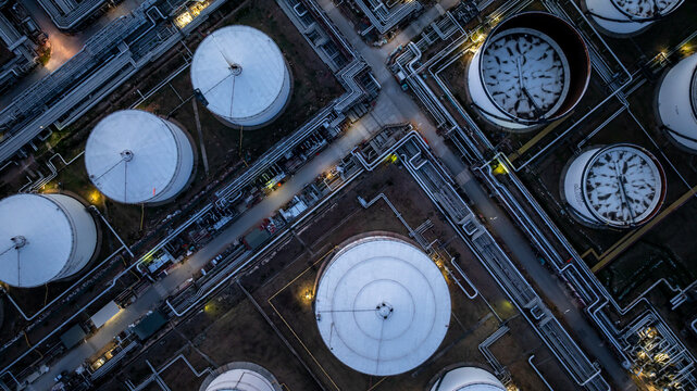 Aerial view oil storage tank and pipeline steel at night, Oil tank storage chemical petroleum petrochemical refinery product, Oil transportation system pipeline steel at oil refinery industry