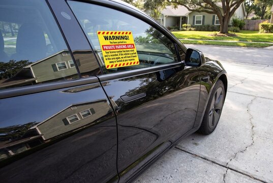 Warning sticker on car window in private parking area