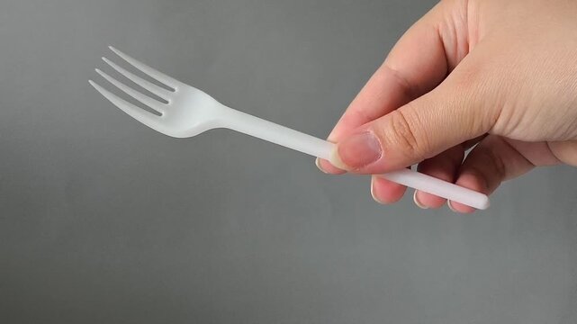 One plastic fork in hand close-up. Disposable tableware set