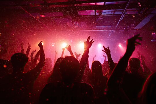 Lively party scene with silhouetted crowd dancing under disco lights