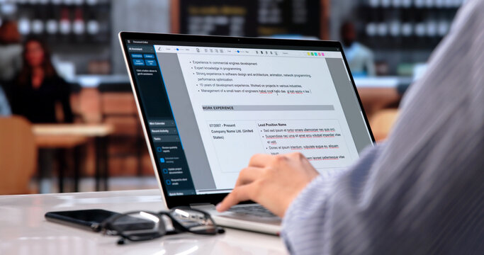 Young Woman Writing Resume On Laptop