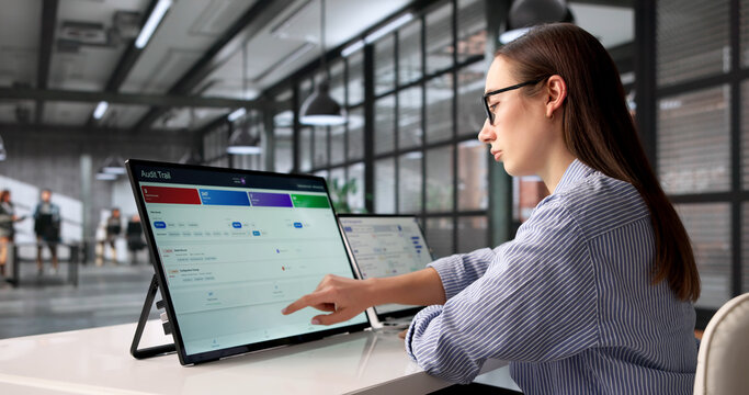 Young Female Auditor Uses Laptop To Track