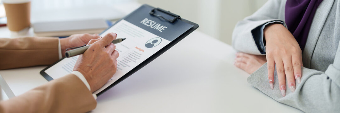 professional recruiter interviewing candidate reviewing resume document on clipboard during job interview meeting hiring process human resources management
