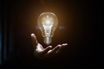 Hand chooses light bulb or lamp icons with business growth icons for human resources or leadership and creativity thinking idea motivation or vision and knowledge learning. © Jintana