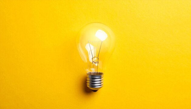Incandescent light bulb symbolizing creativity against bright yellow background