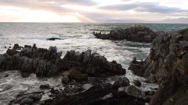 stormy sea meeting rocky coastline of DeKelders, South Africa