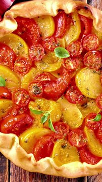 homemade rustic tomato galette, quiche or tart with yellow and red cherry tomatoes, savory vegetable tart with crispy crust and basil