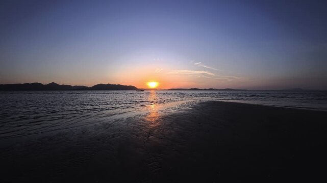 Sunrise over the horizon of a rocky beach on a tropical island in Southeast Asia