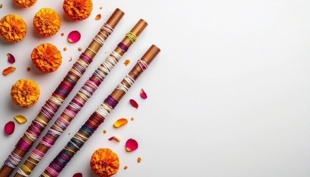 Traditional Indian bamboo flutes with marigold flowers and rose petals on white background