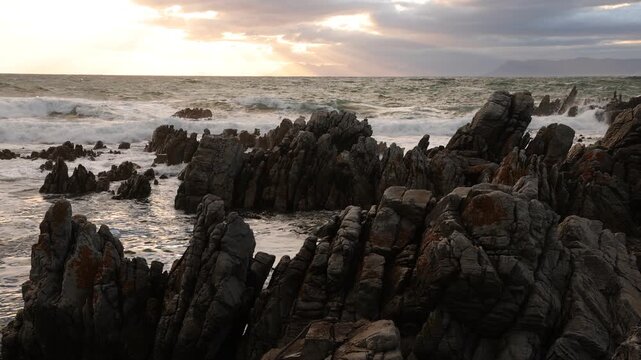 stormy sea meeting rocky coastline of DeKelders, South Africa