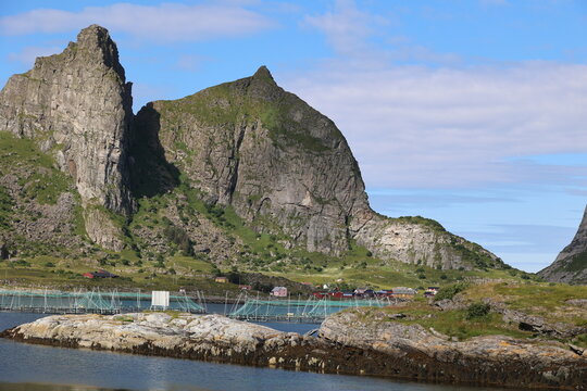 Salmon farm in front of a fantastic rocky backdrop on the island of Traena, Norway