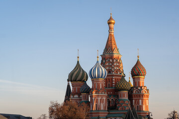 Fototapeta premium St. Basil's Cathedral with colorful onion domes against a clear sky in Moscow, showcasing intricate architectural details and vibrant colors