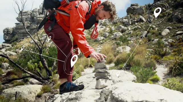 Male hiker entering left, stepping on rock, adjusting cairn while navigation markers tracking route