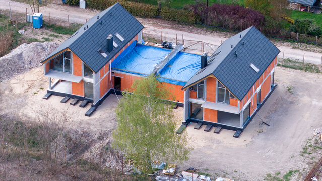Contemporary passive duplex residence with shared garage under construction, aerial view. 