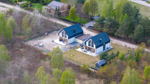 Newly built passive semi-detached family house with shared garage, aerial drone view.